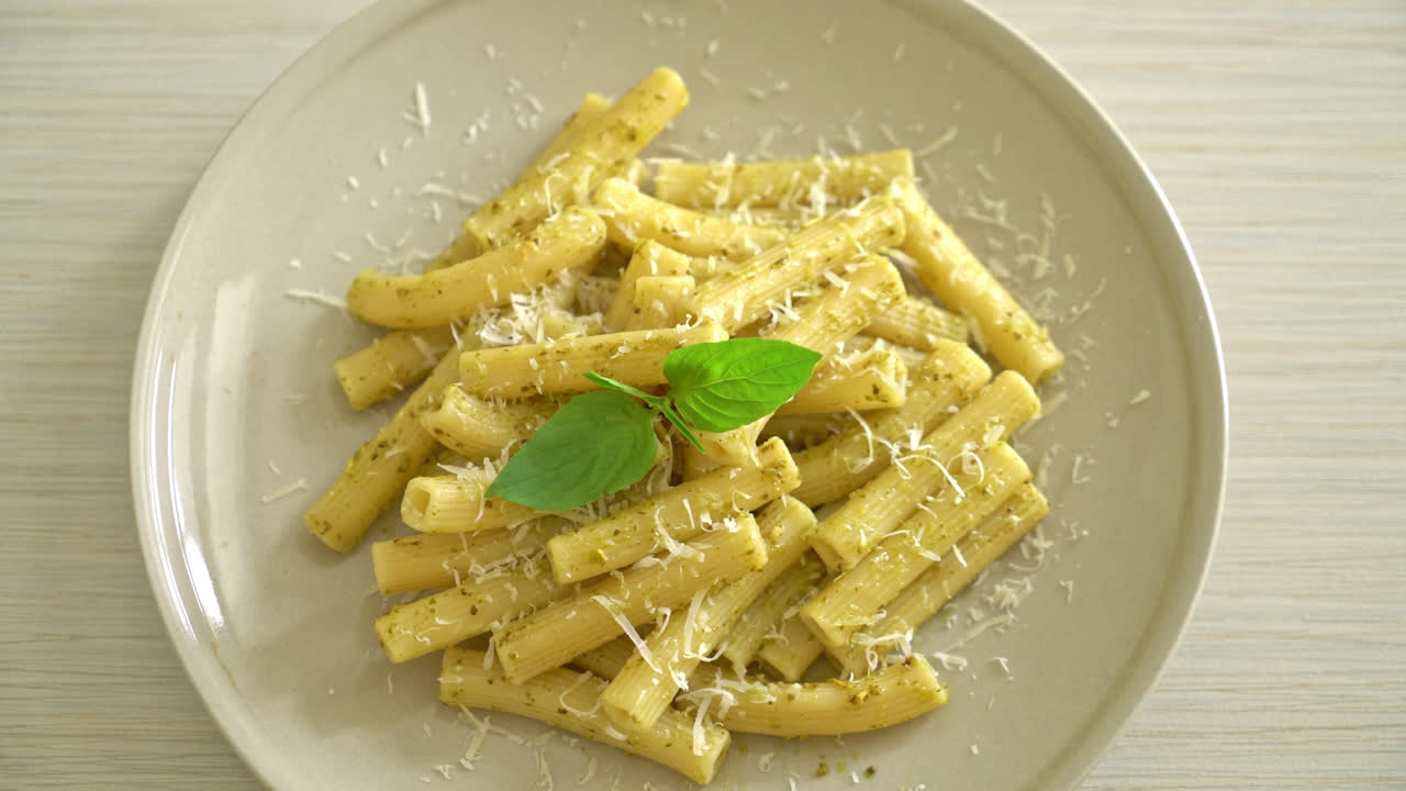 pasta al pesto rigatoni con queso parmesano - comida italiana y comida vegetariana