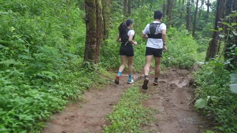 couple trail running in forest
