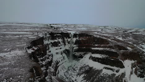 El-Hermoso-Paisaje-Que-Rodea-La-Cascada-Hengifoss,-Al-Este-De-Islandia-En-Un-Día-Nublado-En-Invierno---Toma-Aérea