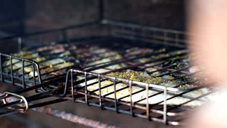 Pez-Negro-Chisporroteando-En-La-Parrilla-Sobre-Fuego-Abierto