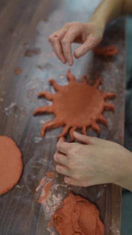 child creating a clay sun