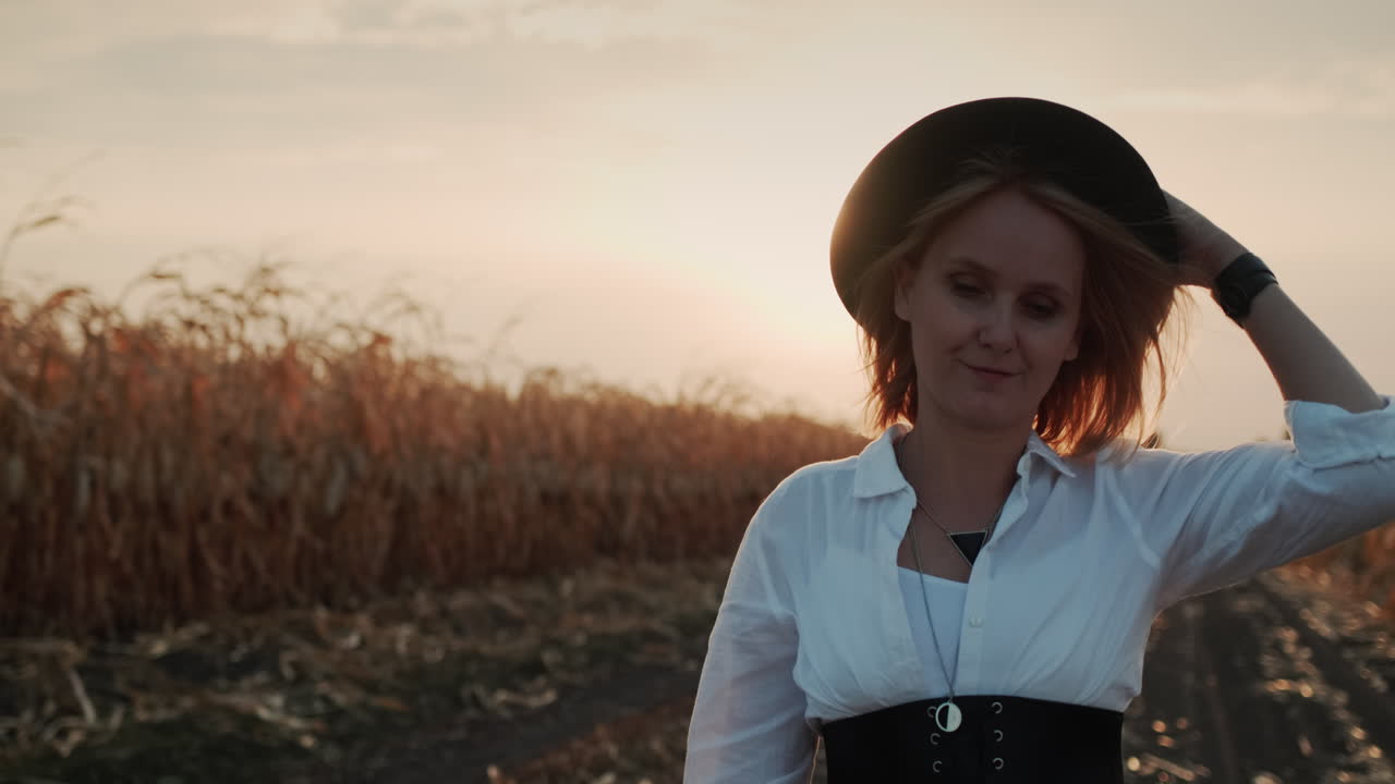 granjero con vestido y sombrero camina en un campo de maíz maduro 11