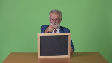 hombre de negocios barbudo y guapo contra un fondo verde.