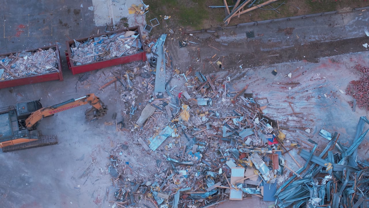 Drone video capturing a construction site in Melbourne, showcasing metal debris, rubble, and machinery. Ideal for industrial, urban transformation themes. Daytime static aerial footage.