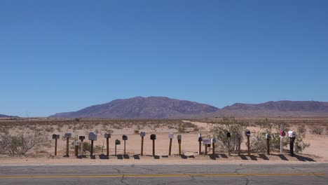 buzones viejos bordean un camino solitario a través del desierto de mojave