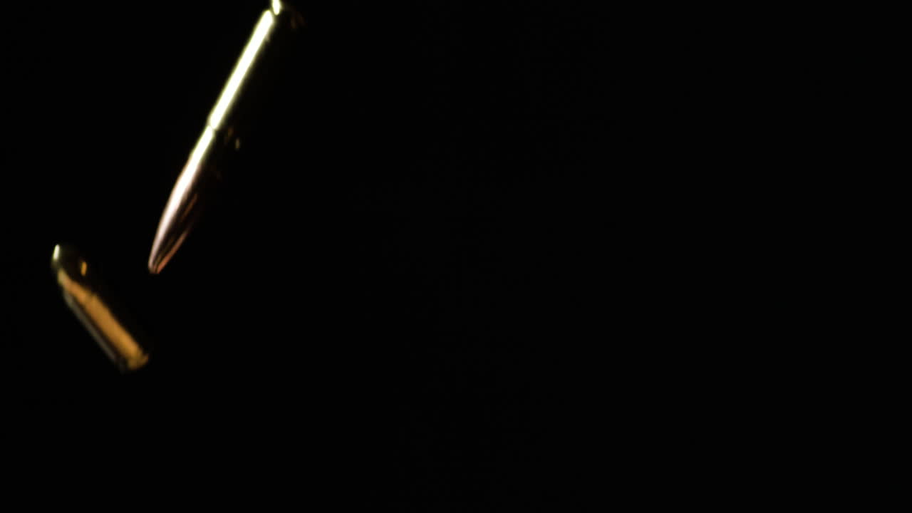 300aac 블랙아웃과 9mm 루거 총알이 검은 바탕에 느린 동작으로 떨어집니다.