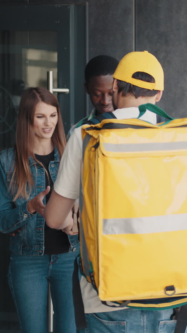 Delivery person greeting a couple at their front door
