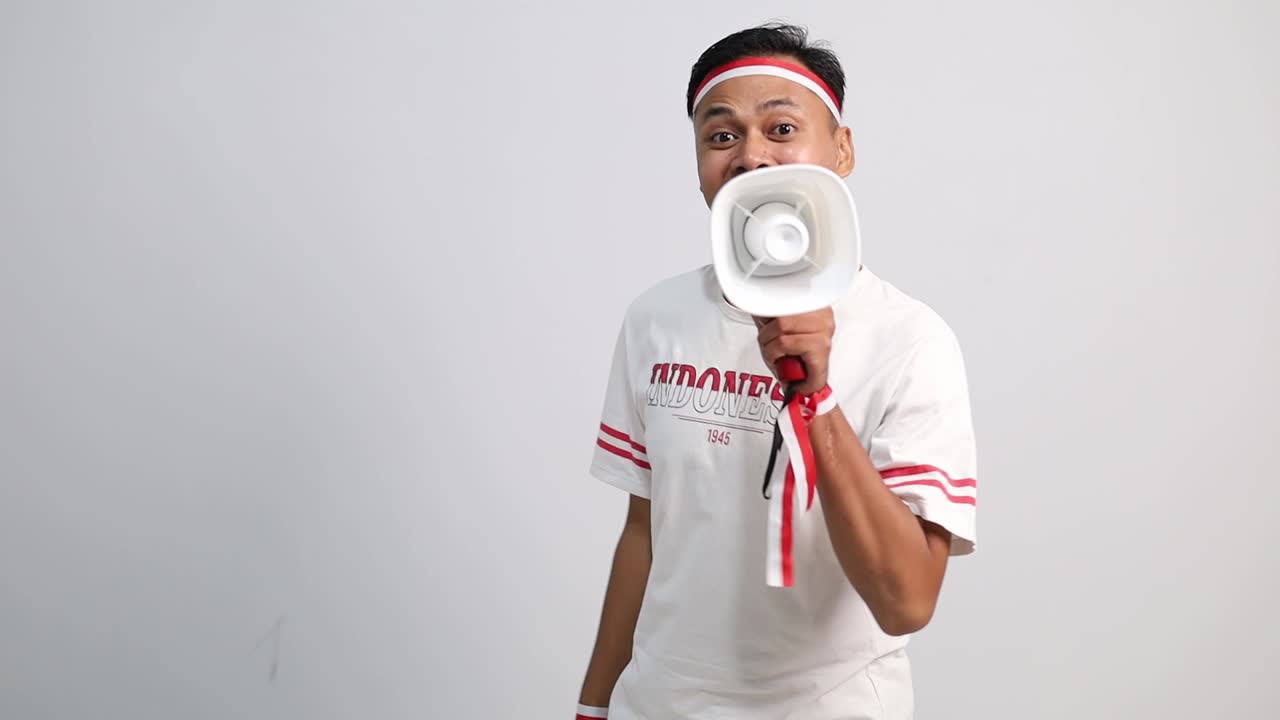 Wow excited indonesian man pointing promotion something on empty space with Indonesia independence day concept