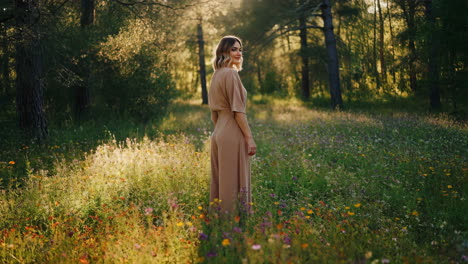 woman in a dress standing in a field of flowers in a forest