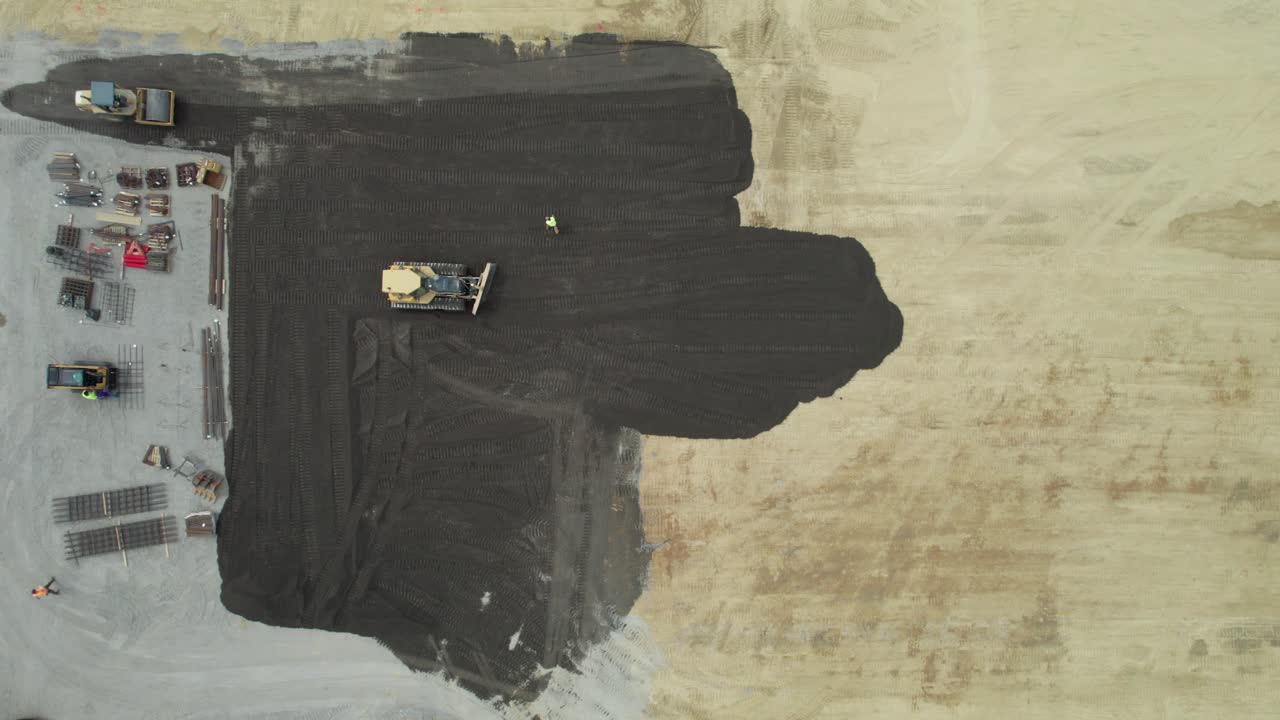 toma aérea de trabajadores de la construcción de carreteras y maquinaria de construcción de carreteras que hacen pavimento