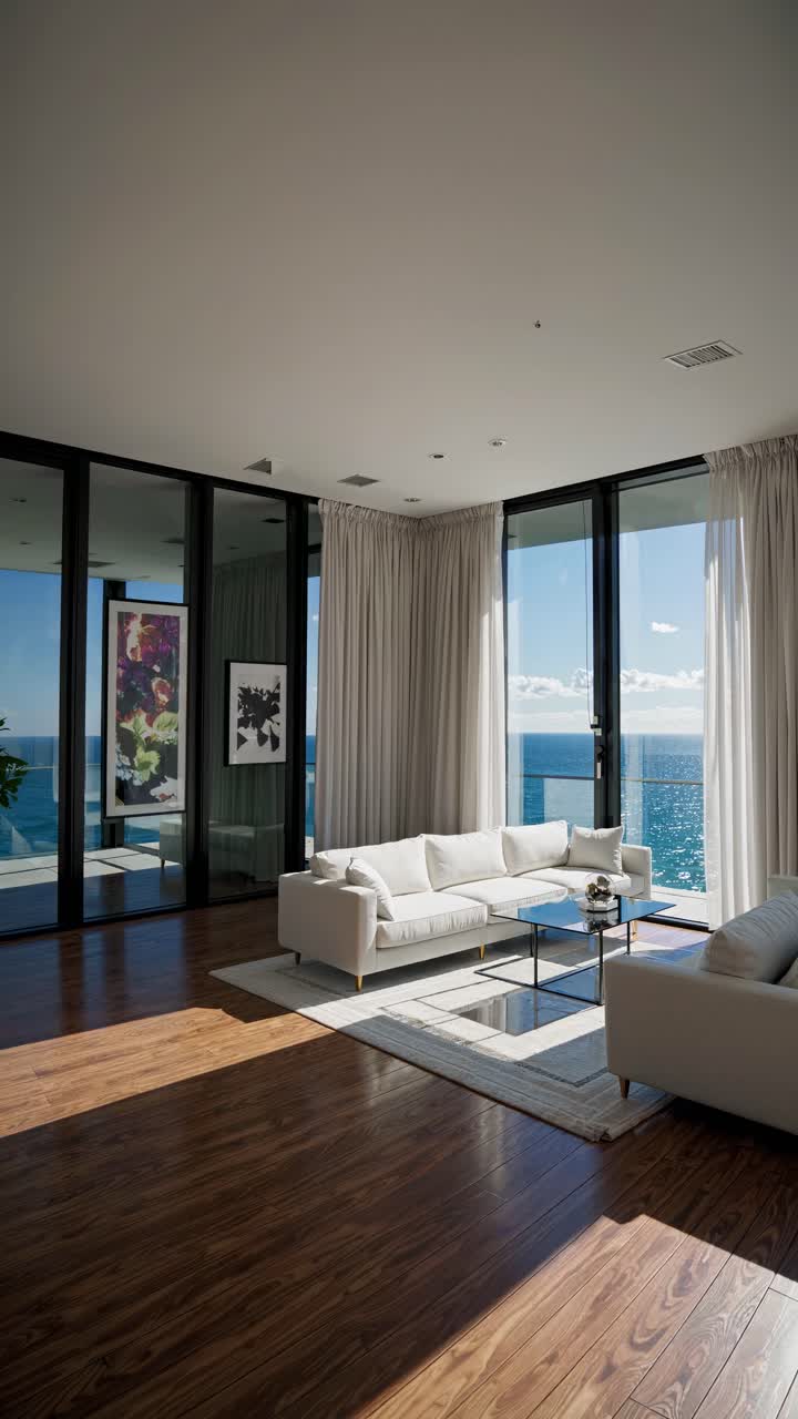 Wide-angle shot of a modern living room with ocean view, sleek furniture, and natural light