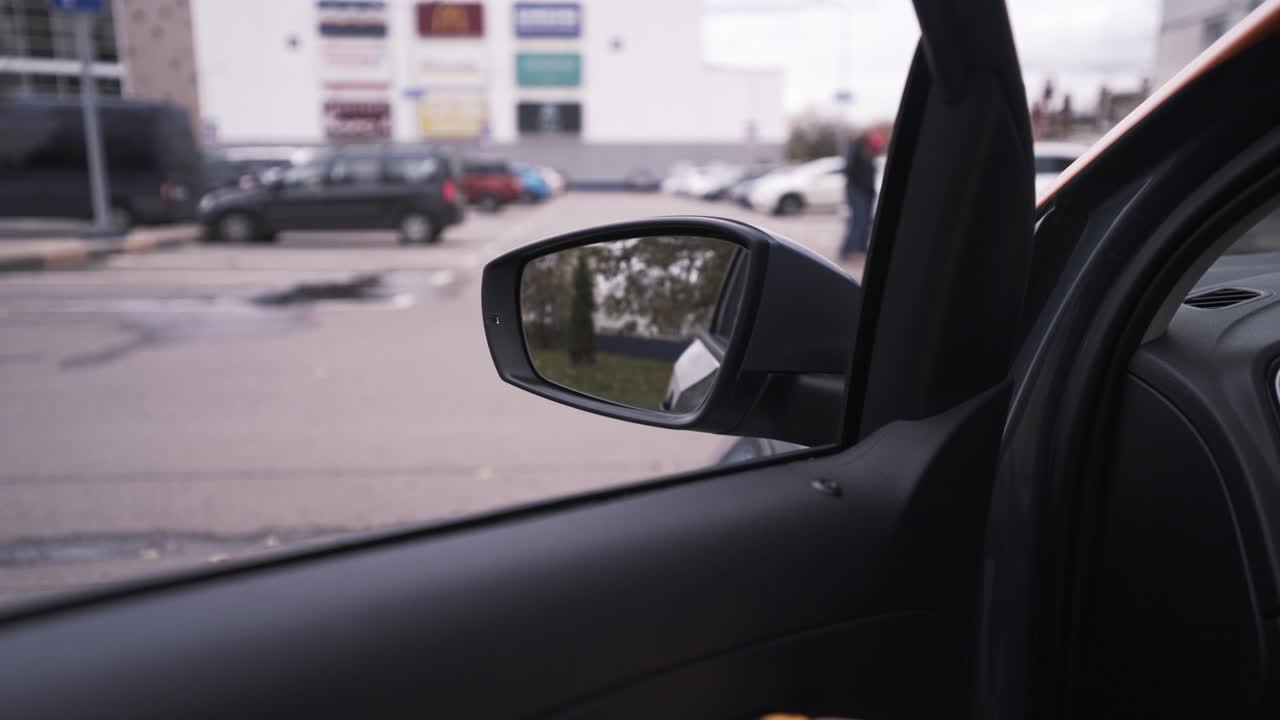 vista del espejo del coche de un estacionamiento con edificios