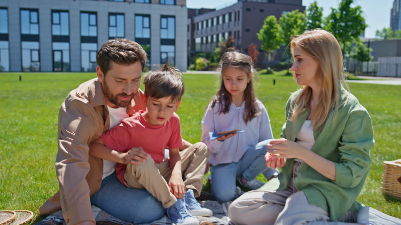 Happy generations sitting sunshine enjoying holiday. Smiling woman giving food
