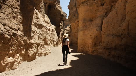 mujer joven en su camino a través de un paisaje rocoso en el desierto de namibia