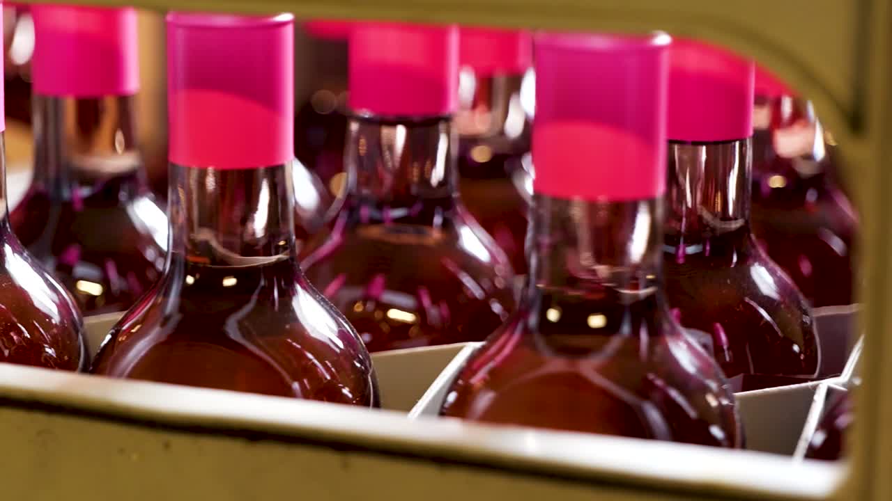 Red Wine Bottles with Pink Caps Ready for Packaging