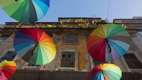 Blick-Auf-Die-Regenbogenschirme,-Die-über-Den-Straßen-Der-Calle-Rosa-In-Lissabon,-Portugal,-Schweben