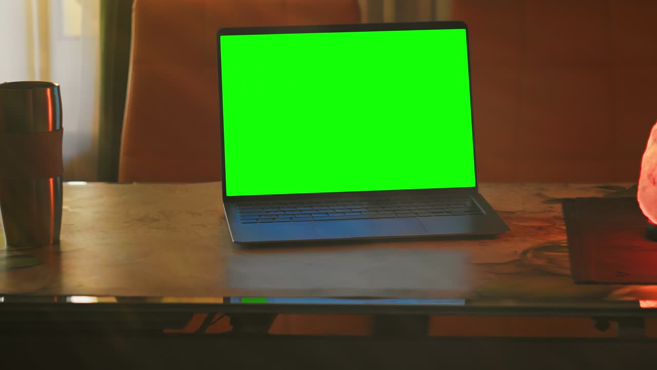 Laptop with green screen in cozy sunlight at home