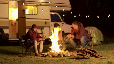 Freunde-Wärmen-Ihre-Hände-In-Einer-Kalten-Nacht-Am-Lagerfeuer