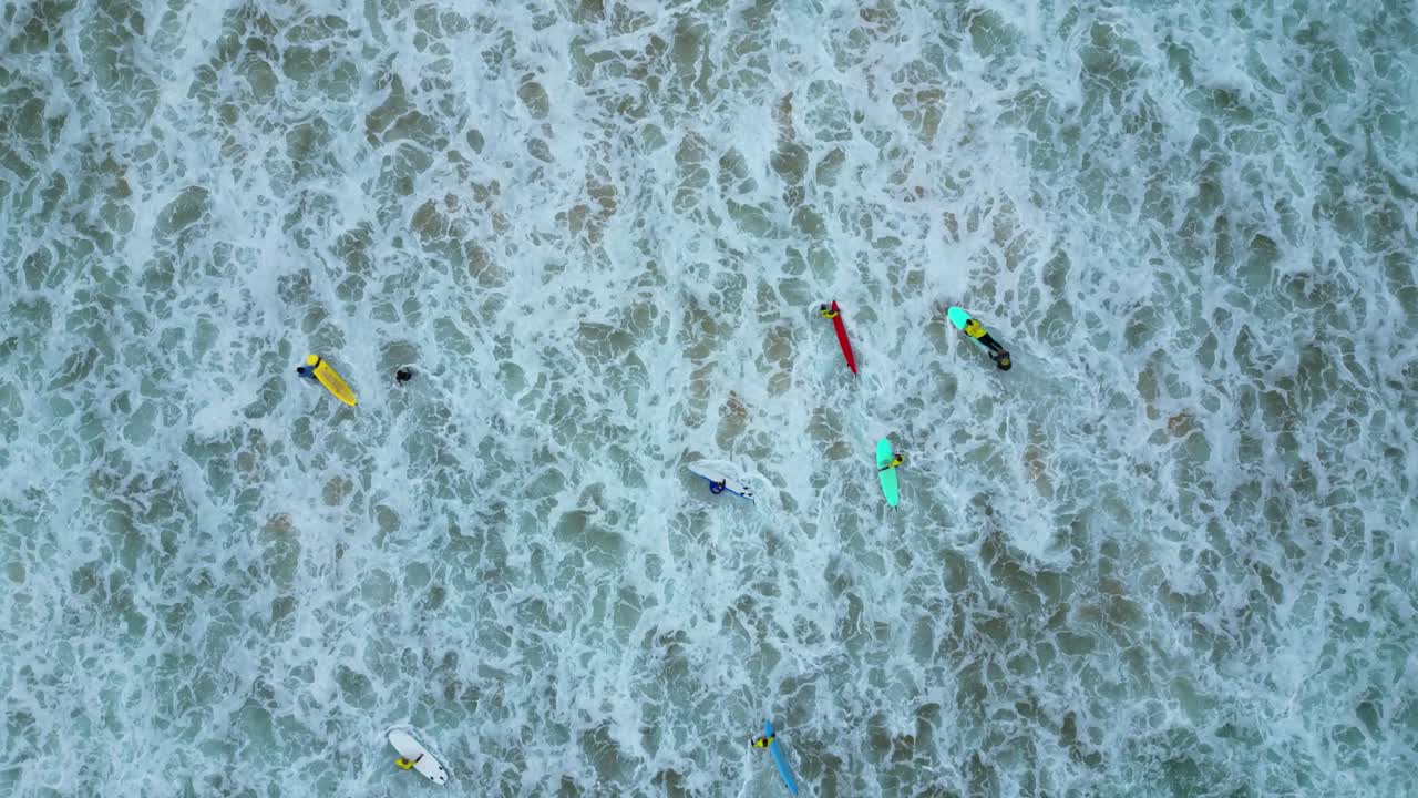 Bird's eye view of a surf school with waves breacking at shore in Guincho beach,Cascais,Portugal