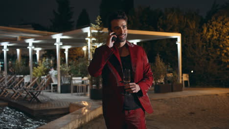 un caballero exitoso hablando por teléfono móvil en una fiesta nocturna de fin de semana.