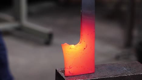 Blacksmiths-forging-hot-metal-with-hammer-in-workshop