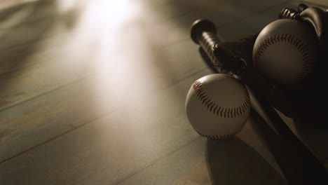 backlit close up studio baseball still life with bat ball and catchers mitt on aged wooden floor 2