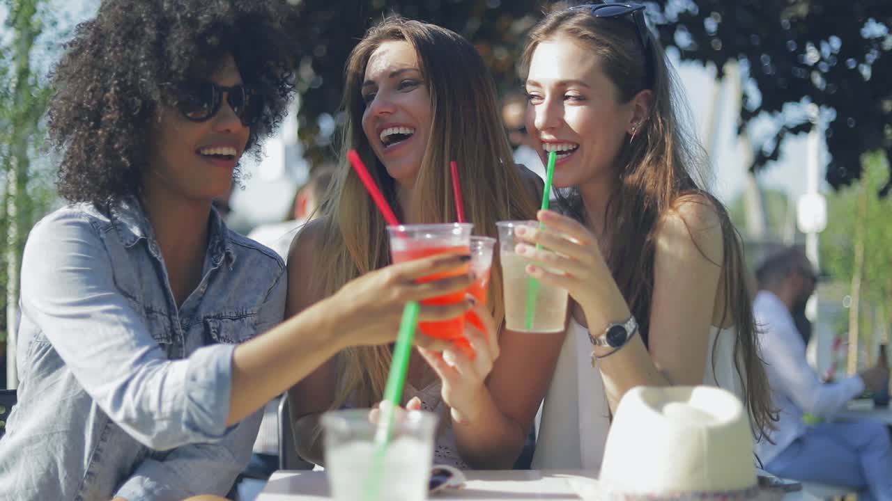 mujeres sonrientes tintineando vasos
