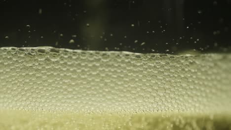 Lite-Beer-poured-into-a-glass-close-up-with-a-black-background-in-slow-motion