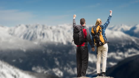 rear view of couple with backpack standing against winter landscape with snowy mountain ranges