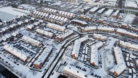 hermosa imagen aérea de un coche conduciendo a través de un impresionante barrio suburbano cubierto de nieve