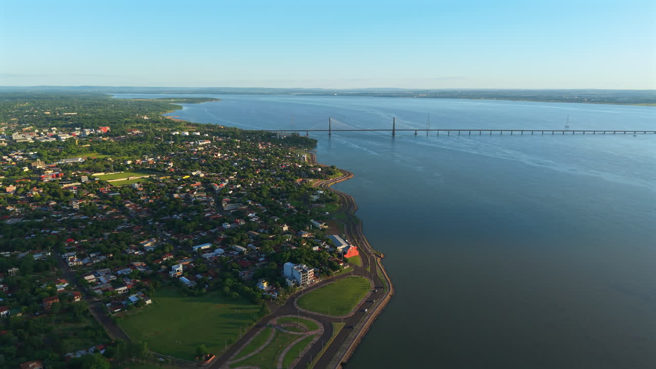 Bridge crossing Paraguay and Argentina Paraná river border, Aerial view of Encarnación city, waterfront landscape