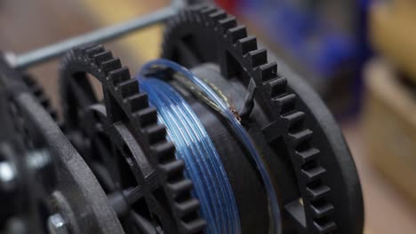 mechanical gears in operation with a blue cable