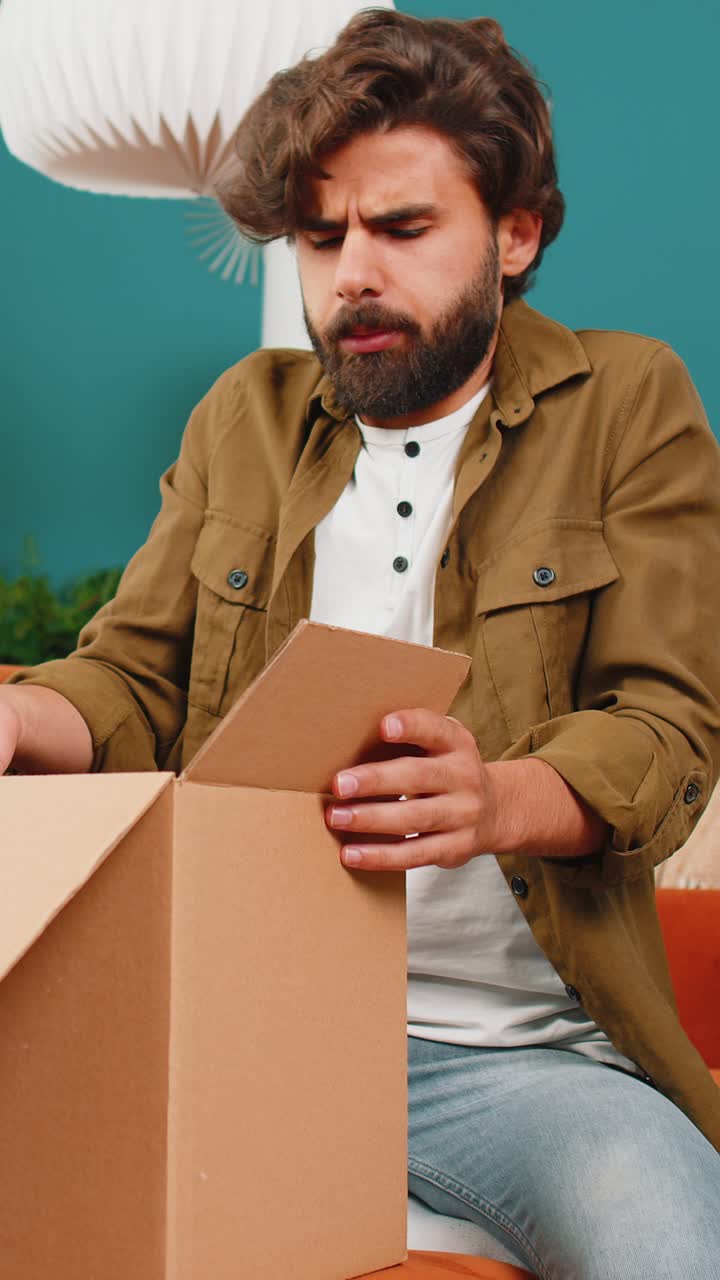 comprador enojado insatisfecho hombre de oriente medio desempaquetando un paquete sintiéndose molesto confundido entrega incorrecta