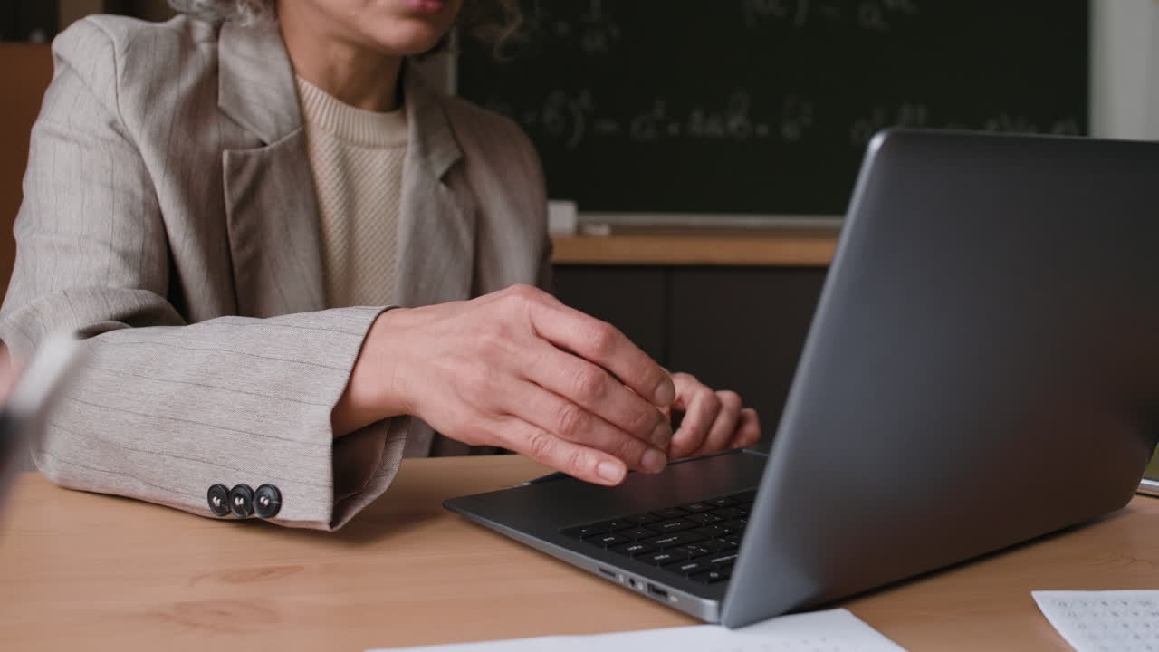 Teacher using a laptop in a classroom
