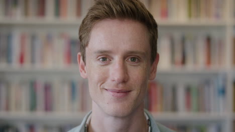 close-up-portrait-young-red-head-man-student-smiling-enjoying-relaxed-college-lifestyle-in-bookshelf-background