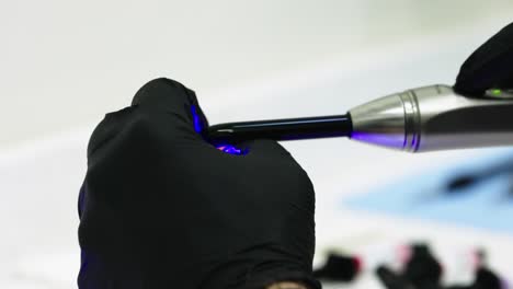 primer plano de un dentista usando luz ultravioleta para pegar el prototipo