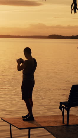 Photographer taking picture of sunset at local beach which is tourists point. Beautiful summer sunset.. Vertical video