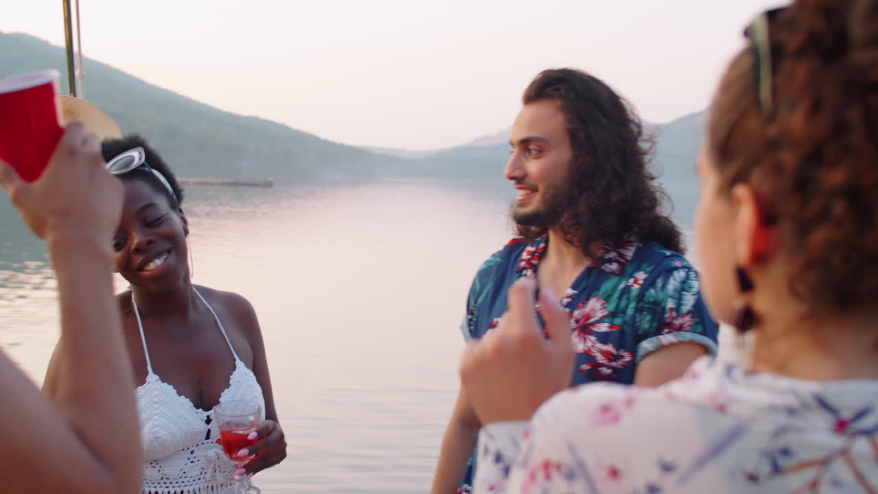다민족 친구들이 호수 파티에서 춤을 춘다