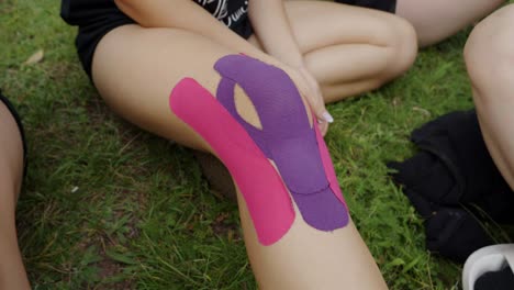 colorful kinesio tapes applied on the legs of dancers waiting for rehearsals
