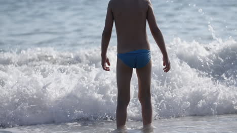 niño jugando en las olas del océano