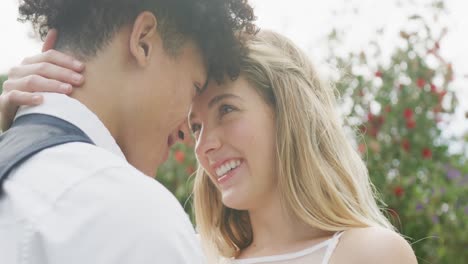 Happy-diverse-couple-in-garden-on-sunny-day-at-wedding