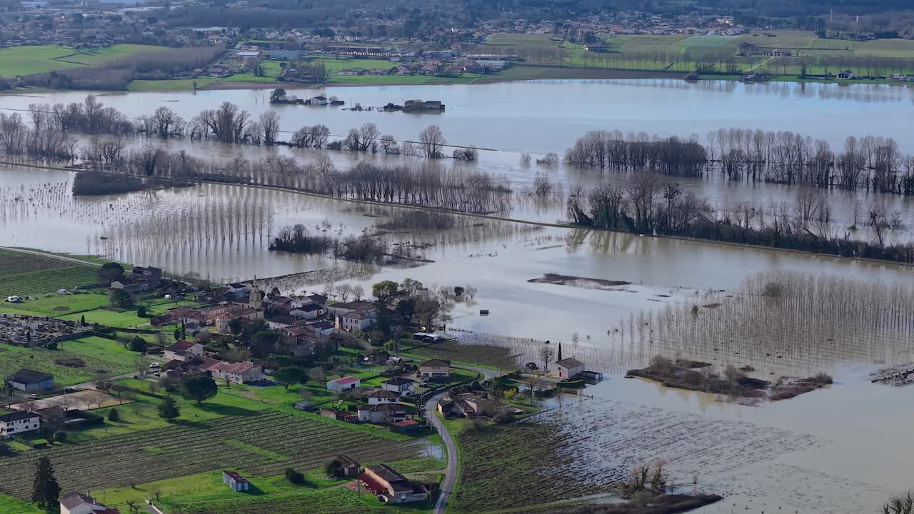 Luftaufnahme von Hochwasser, das eine Landschaft aus Weinbergen und ein einsames Gebäude unter Wasser setzt und ein Bild der Verwüstung schafft. Überschwemmtes Feld, Gironde, Frankreich.