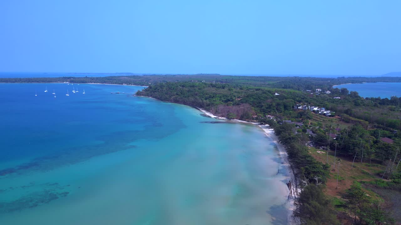 Koh Mak tropical beach meeting turquoise water under blue sky in Thailand. Gorgeous aerial view flight descending drone