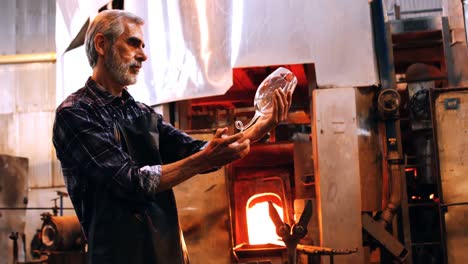 glassblower examining glass