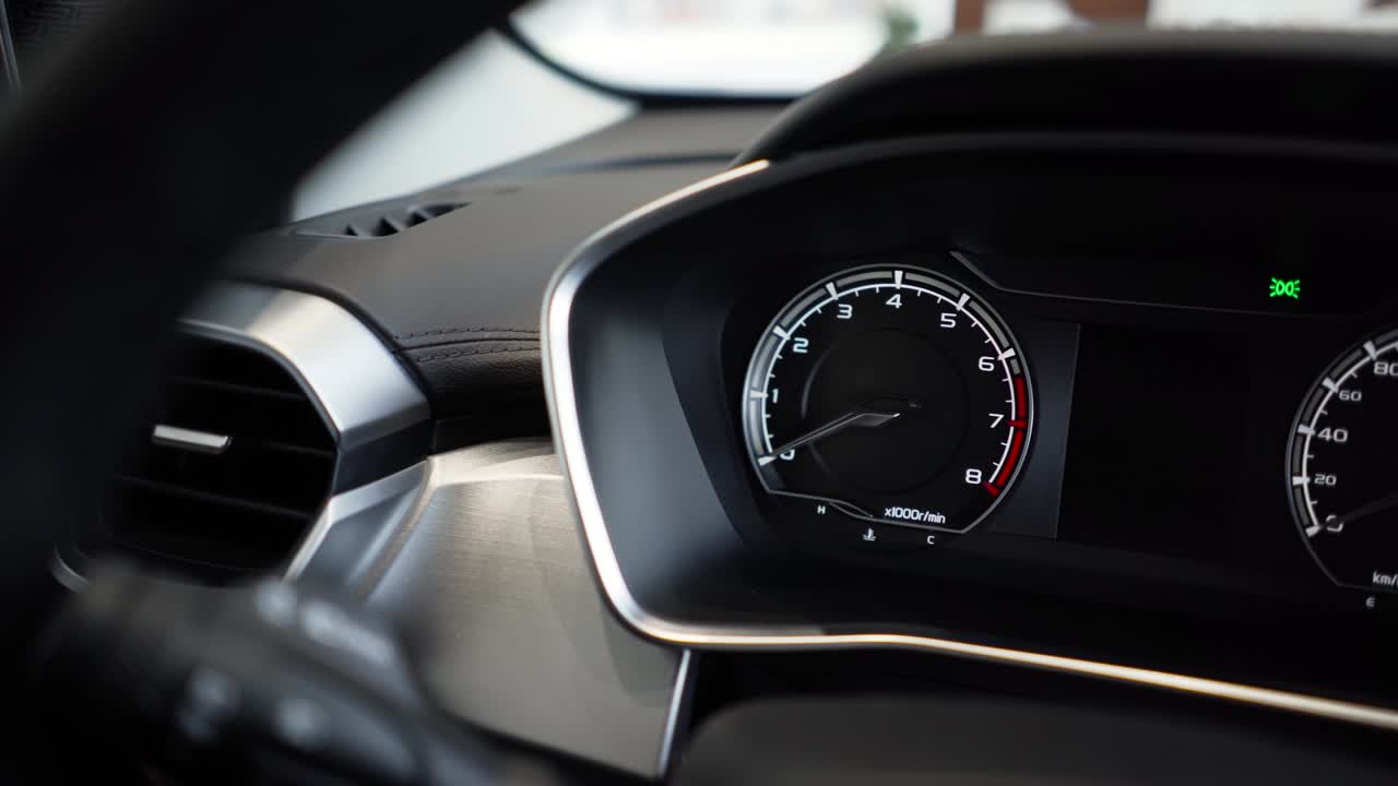 Close up of car speed meter. Interior of a modern car, dashboard with an engine speed dial and moving arrow