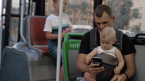 father with two kids traveling by bus