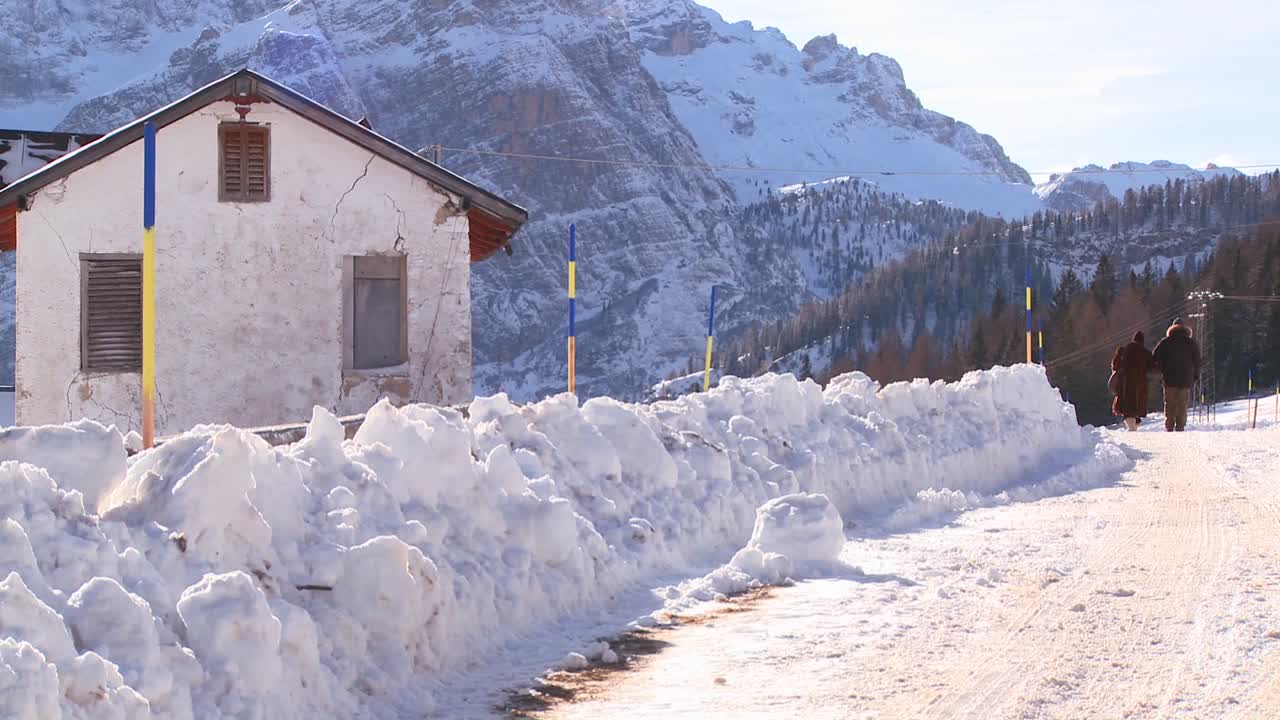 una pareja de ancianos camina por un camino cubierto de nieve en los alpes suizos