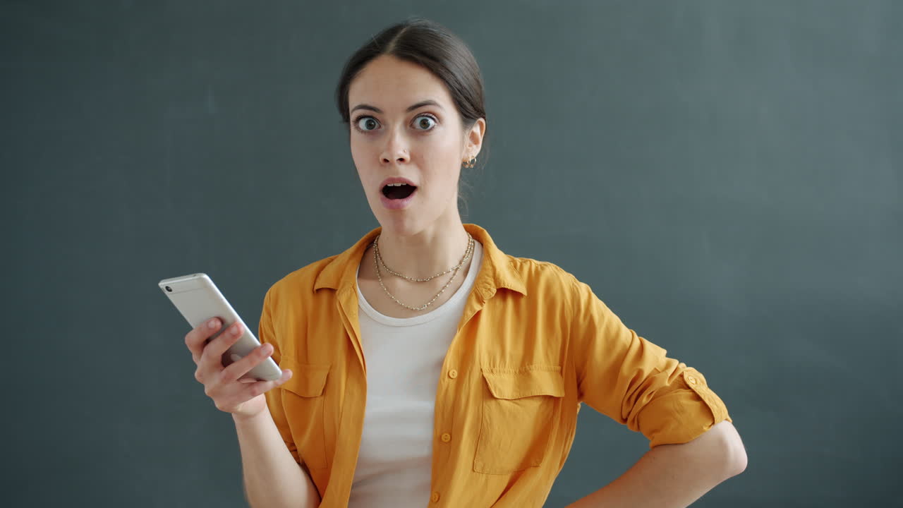 Woman reacting with surprise to something on her phone