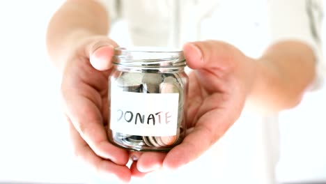 hand holding donation money jar to invite and encourage for helping other , charity and help giving money concept , 4k dci resolution