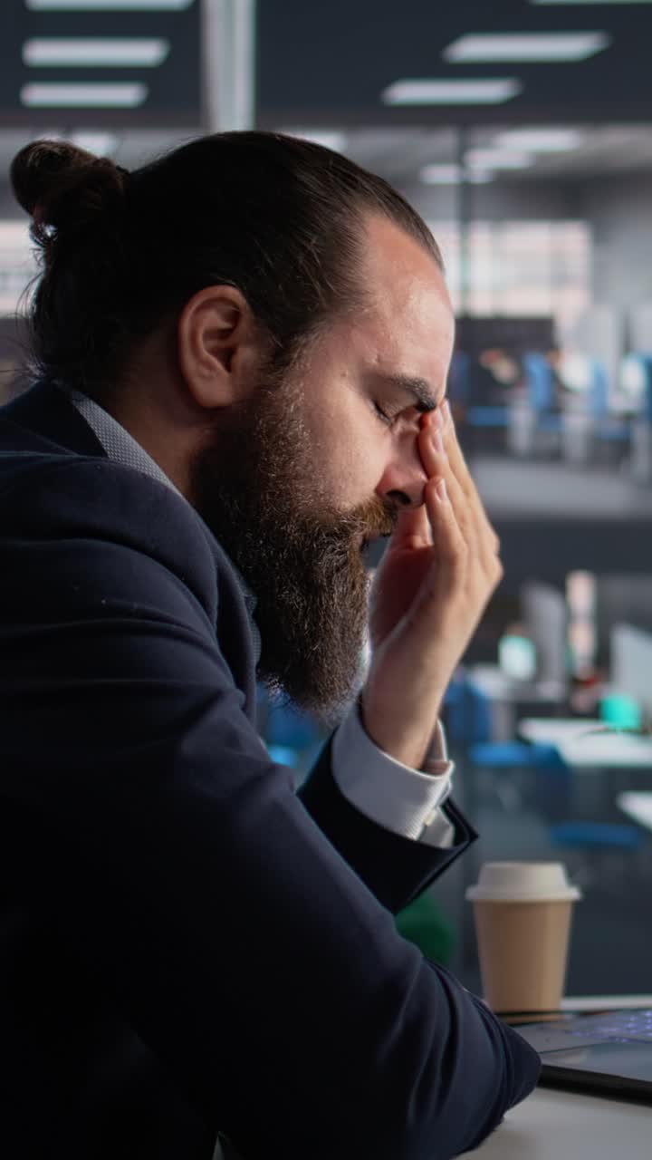 Mal di testa da video verticali in ufficio, persona che si massaggia le tempie e ha affaticamento agli occhi, CEO a disagio